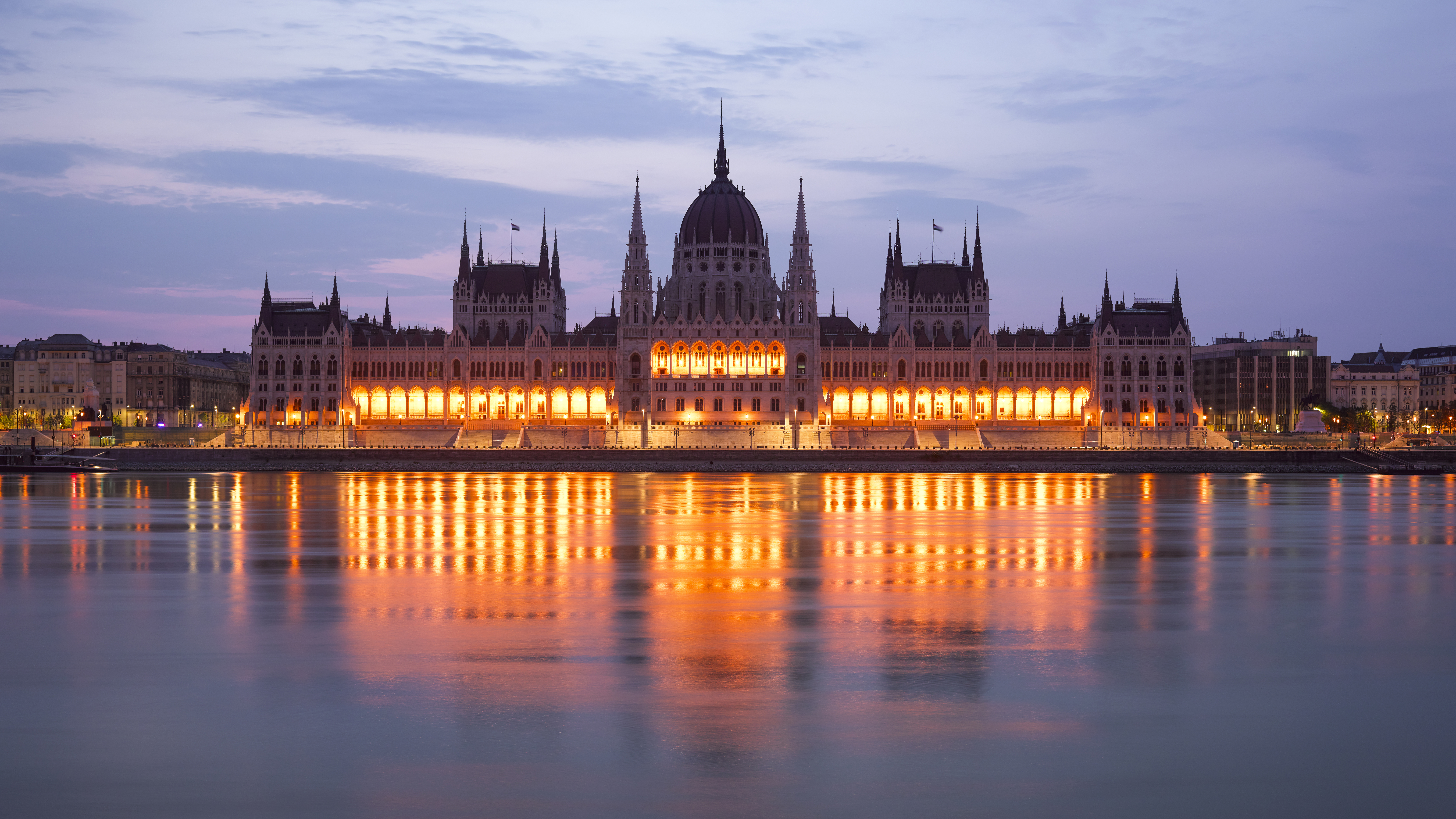 A picture of the Danube river with the Budapest Parliament in the background at night.